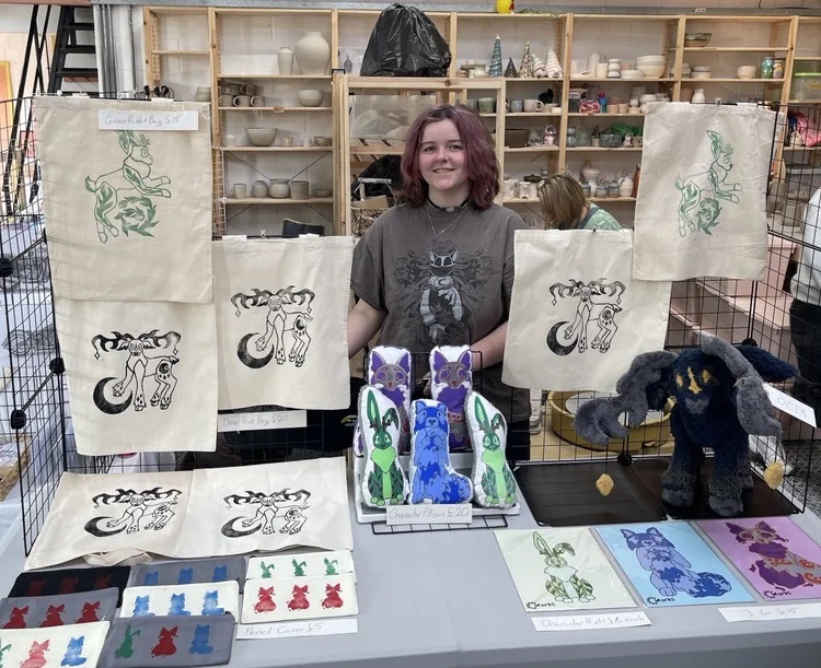 Student Ella Grace-Wells selling her art work at Claire's House