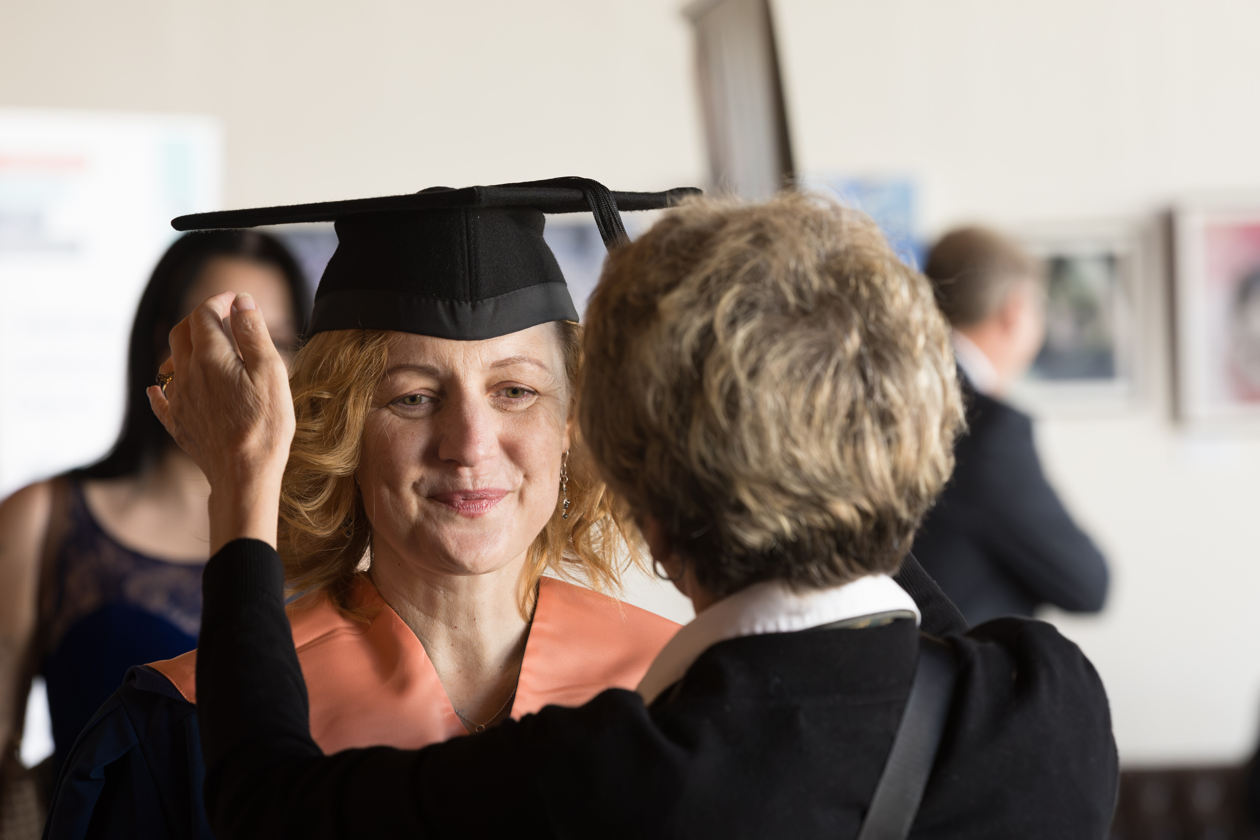 A graduate getting gowned up.
