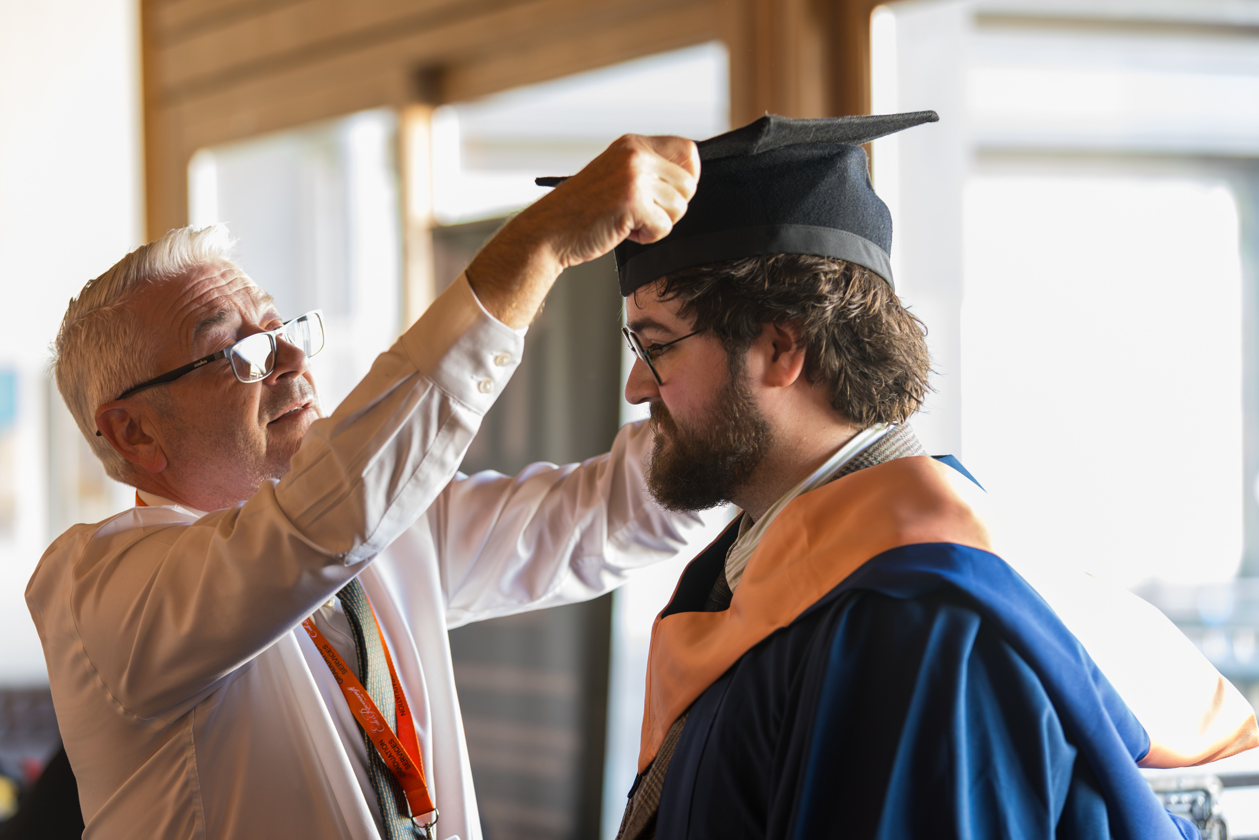 A graduate getting gowned up.