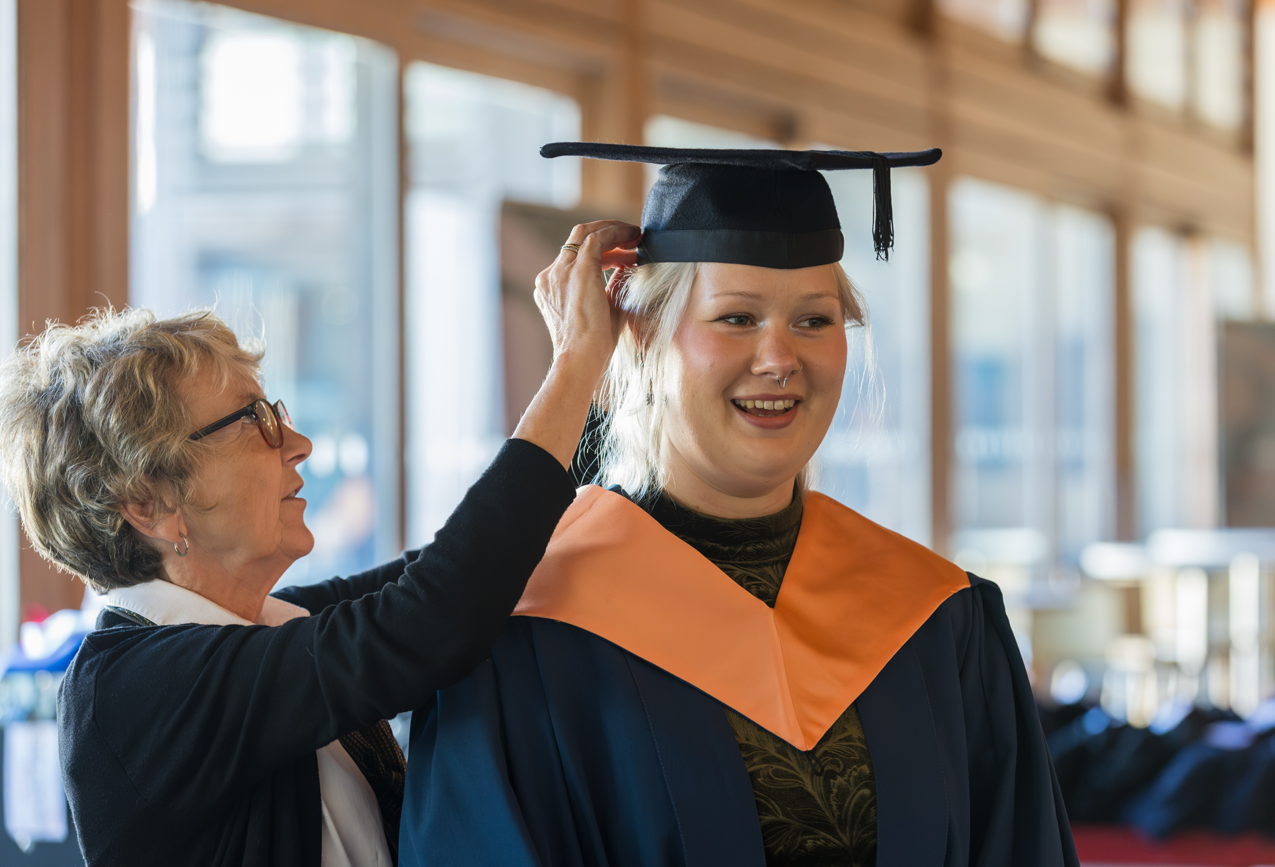A graduate getting gowned up.