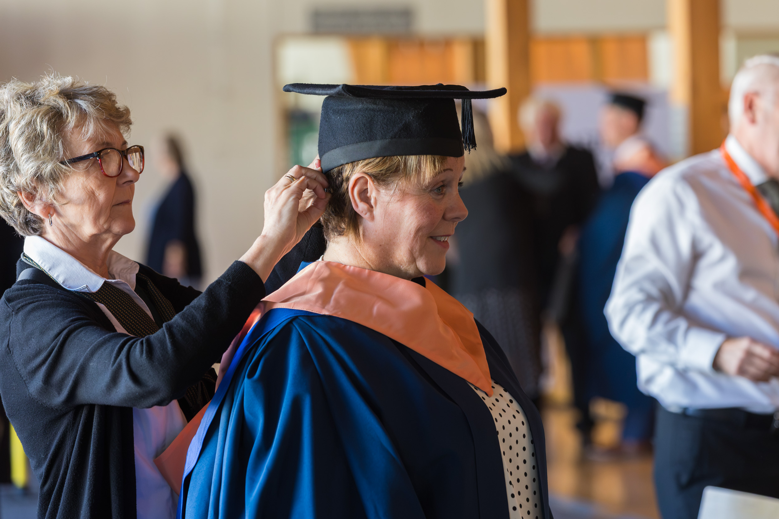A graduate getting gowned up.