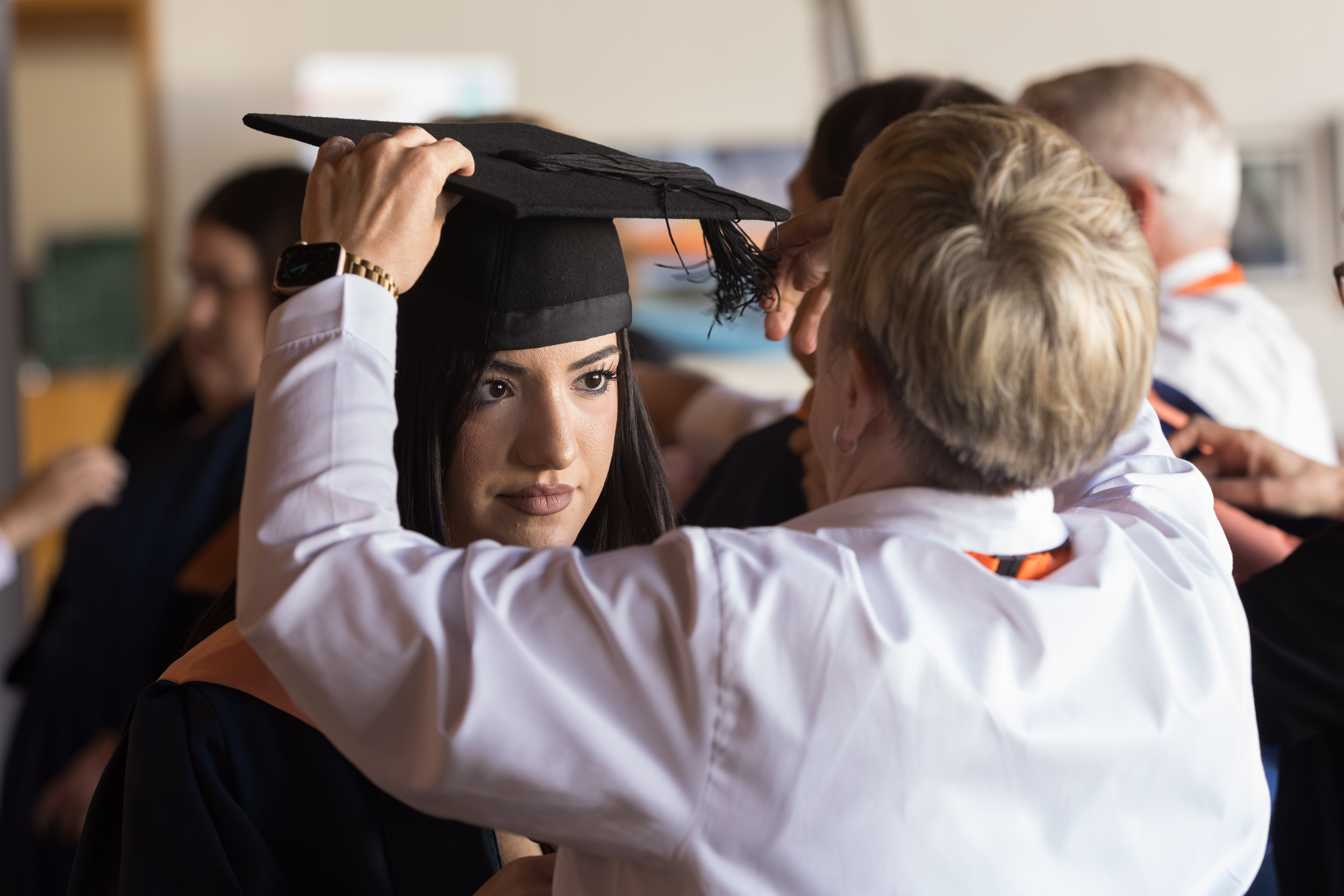 A graduate getting gowned up.