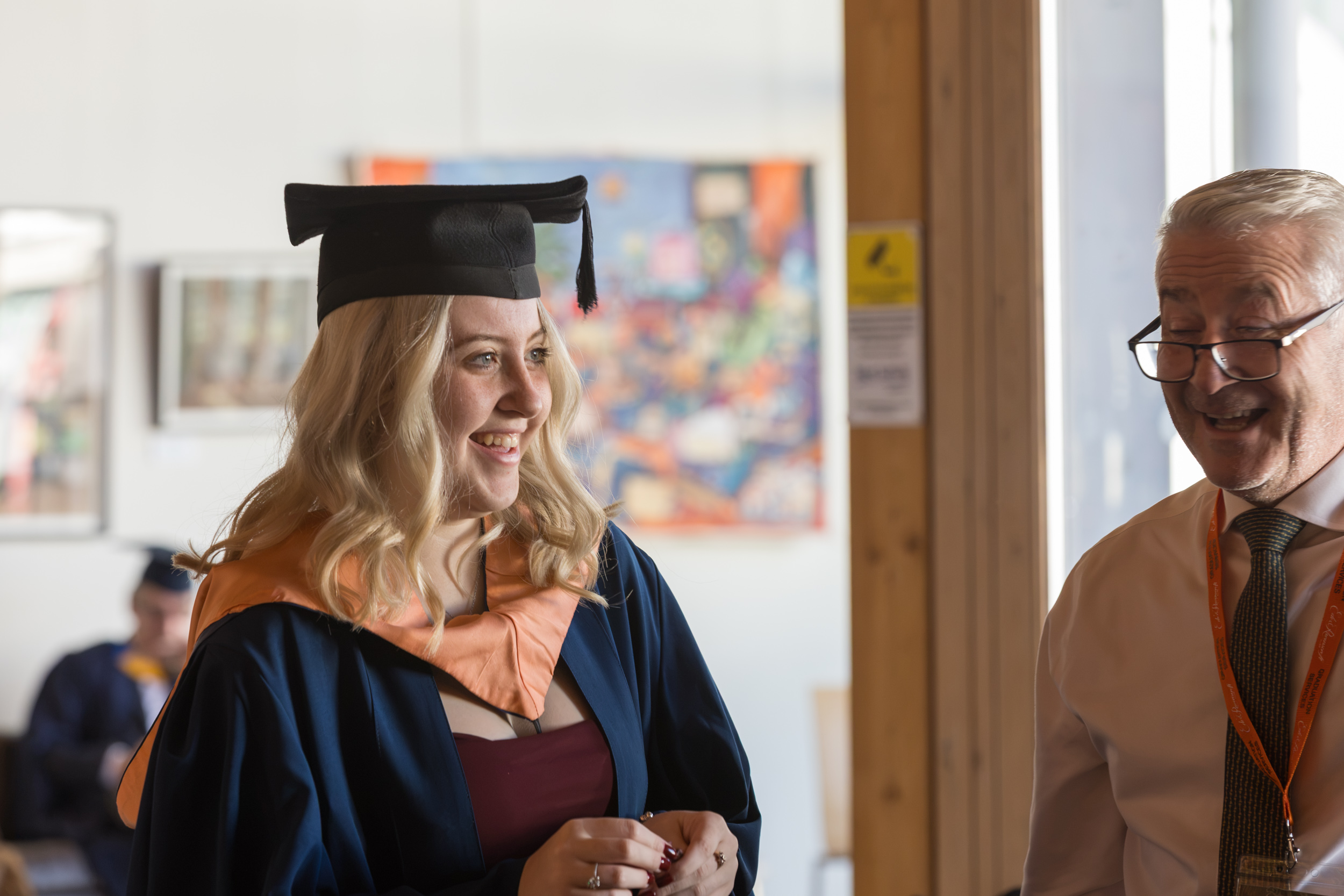 A graduate getting gowned up.