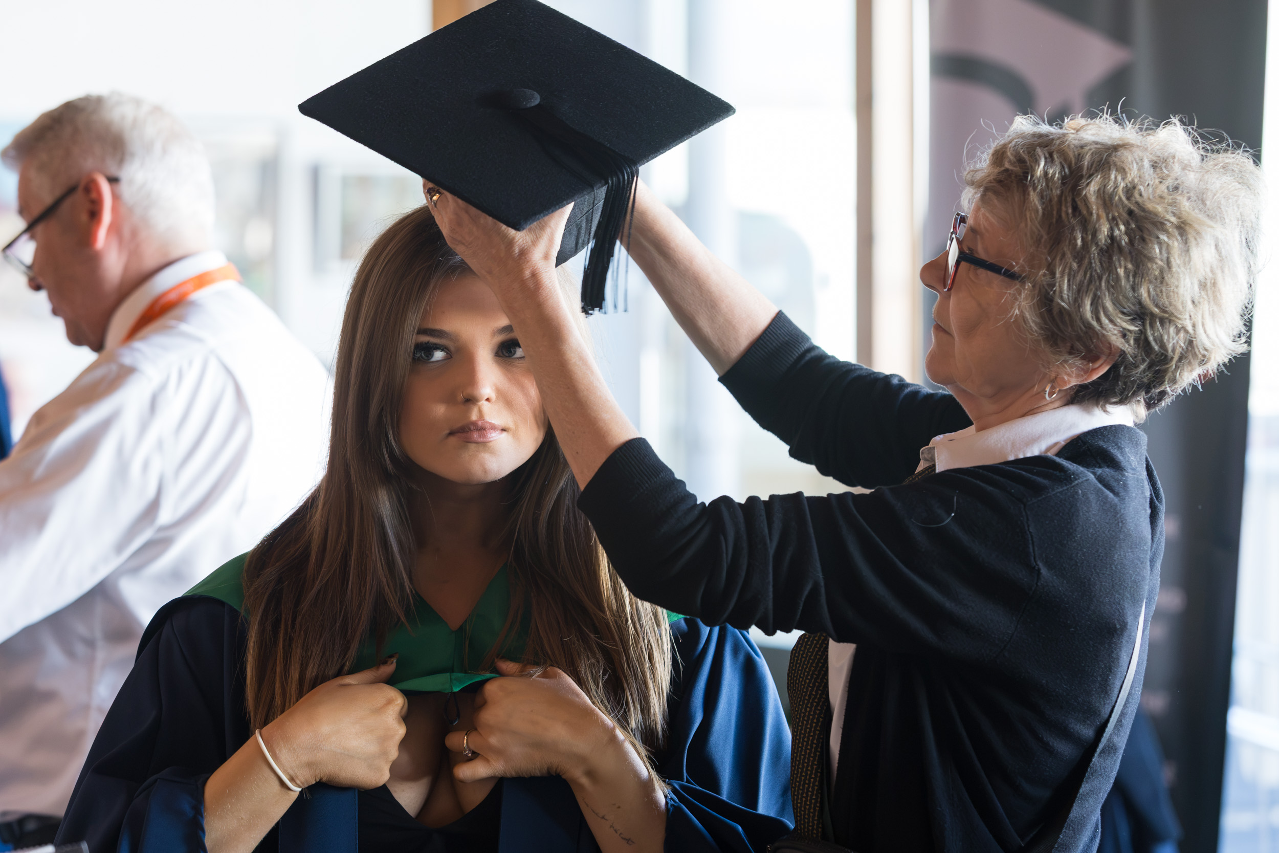 A graduate getting gowned up.