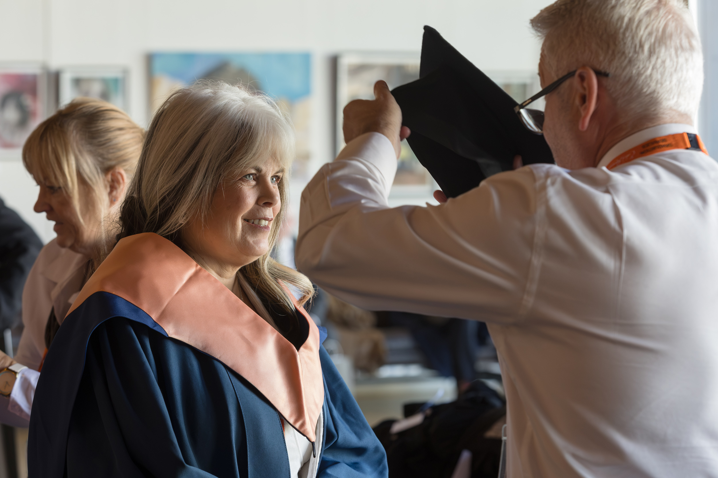 A graduate getting gowned up.