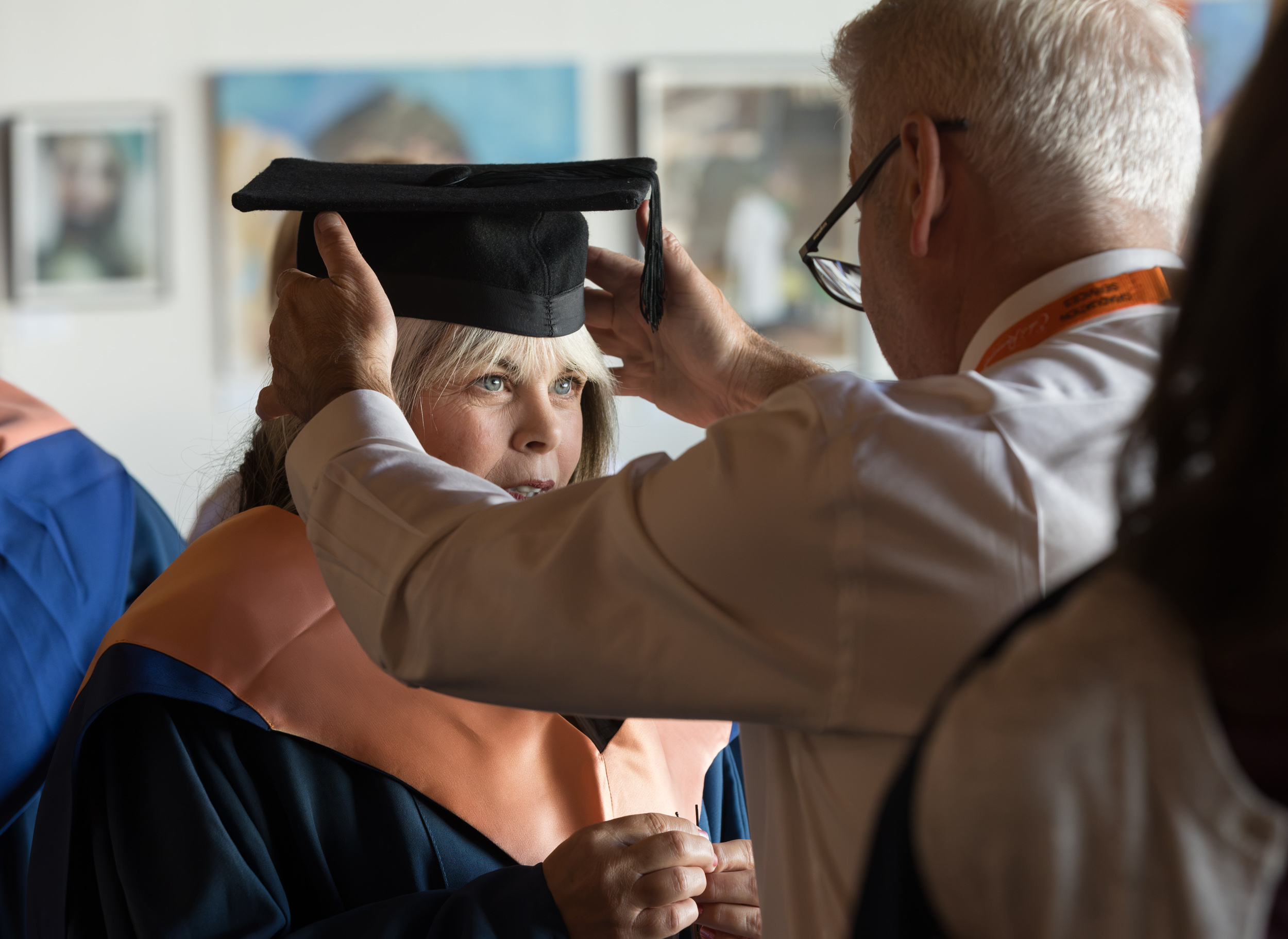A graduate getting gowned up.