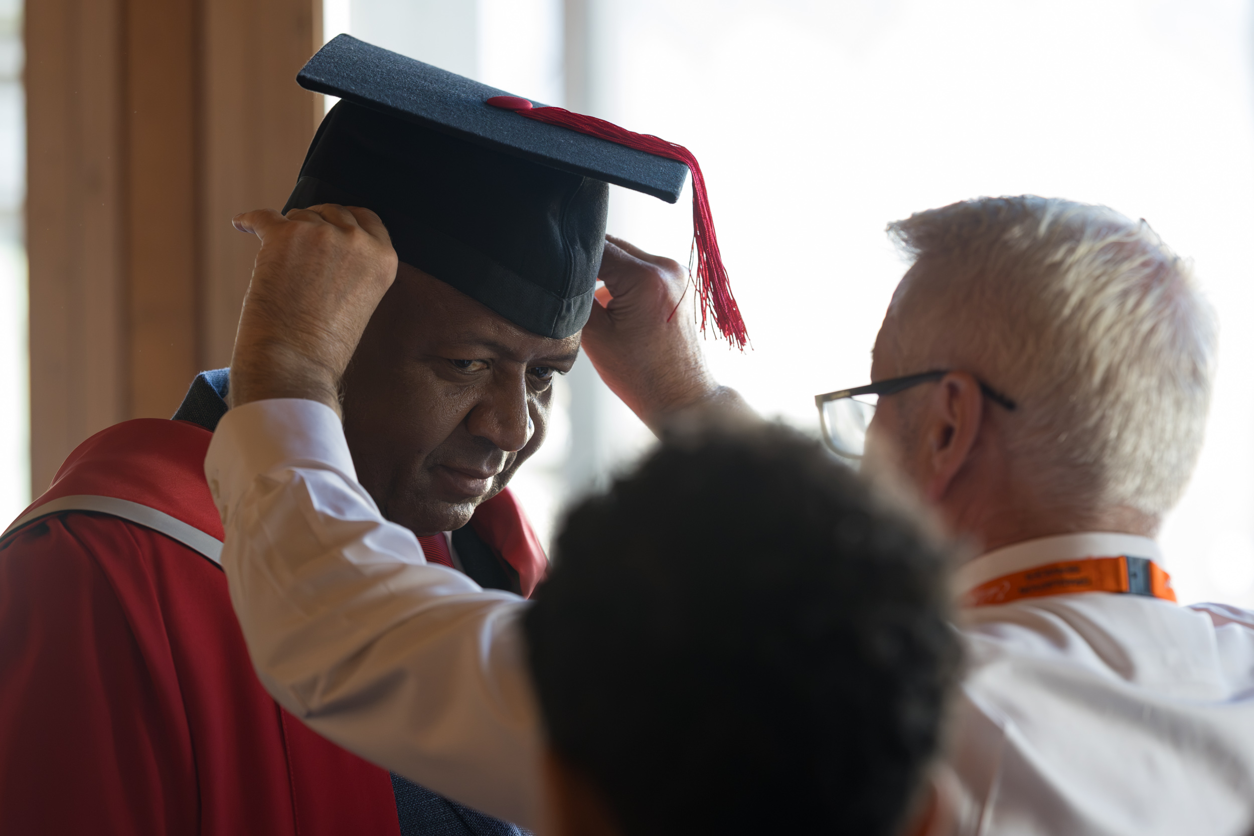 A member of staff from university getting gowned up.