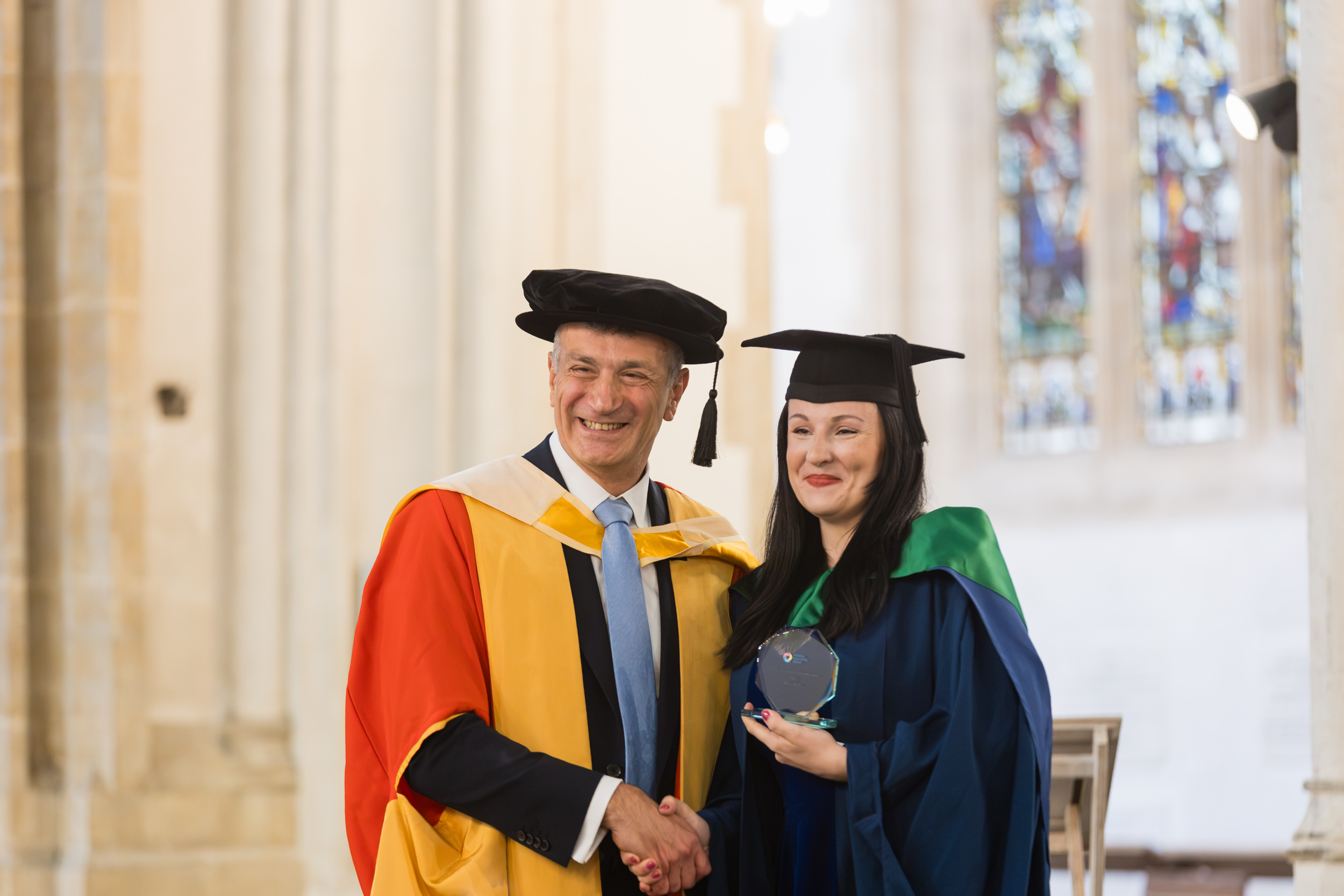 A female graduate at St Edmundsbury Cathedral with Dr Nikos Savvas