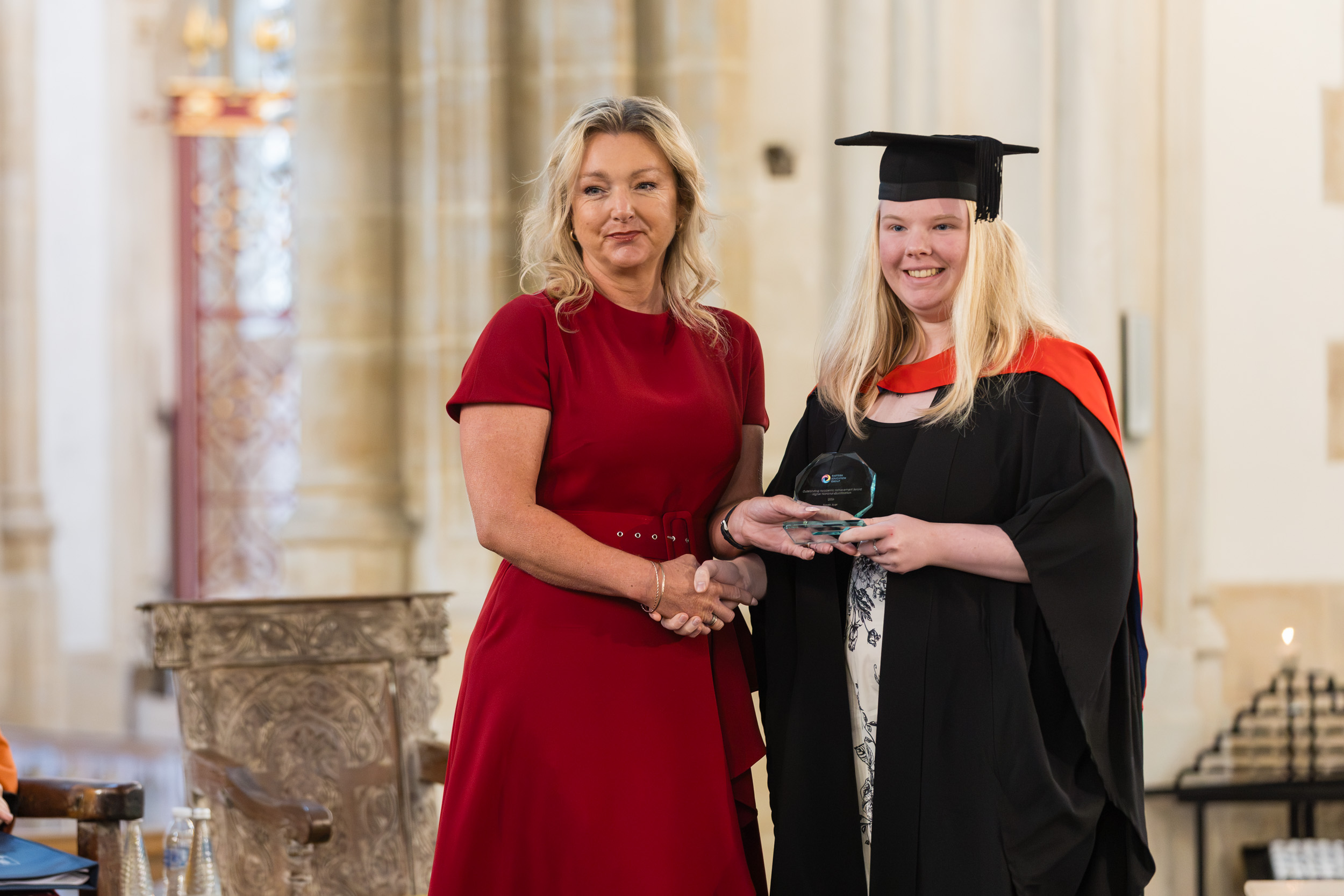 Smiling ladies on stage at graduation